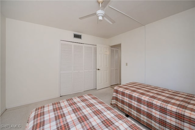 unfurnished bedroom with a closet, visible vents, ceiling fan, and light carpet