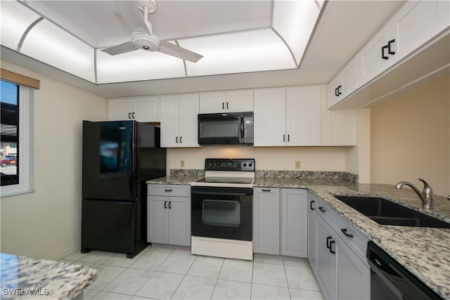 kitchen featuring light stone counters, a sink, a ceiling fan, white cabinets, and black appliances