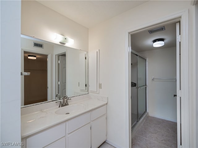 full bathroom with a stall shower, visible vents, and vanity