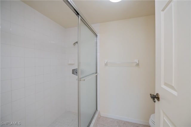 full bath with toilet, a shower stall, and baseboards