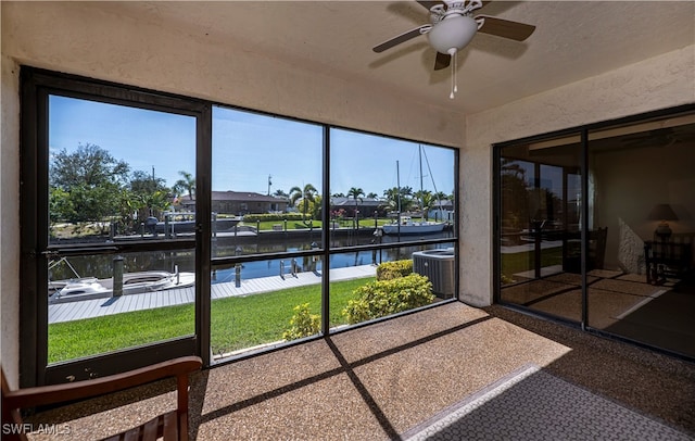 sunroom / solarium featuring a water view and ceiling fan