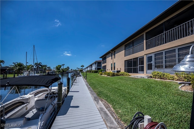 dock area featuring a water view and a lawn