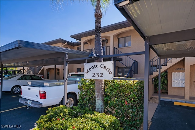 exterior space featuring stairs, parking, and stucco siding