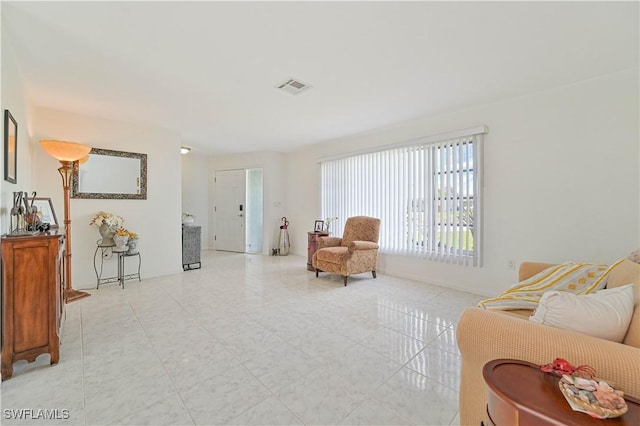 living area with visible vents and light tile patterned floors