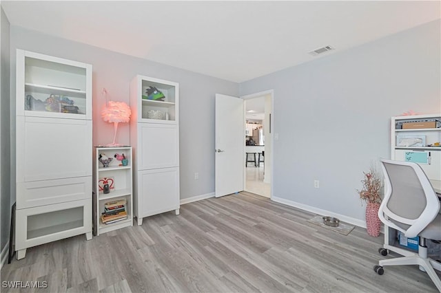 office space with light wood-type flooring, baseboards, and visible vents