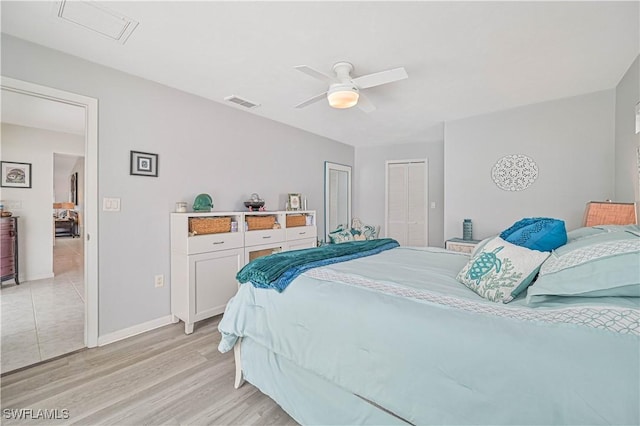 bedroom with baseboards, light wood-style flooring, visible vents, and a ceiling fan