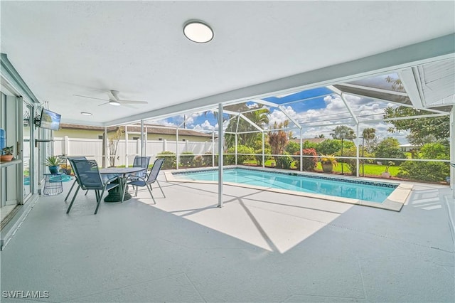 view of pool with ceiling fan, glass enclosure, a patio, fence, and a fenced in pool