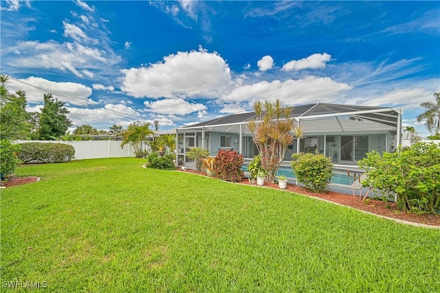 view of yard with a lanai, fence, and an outdoor pool