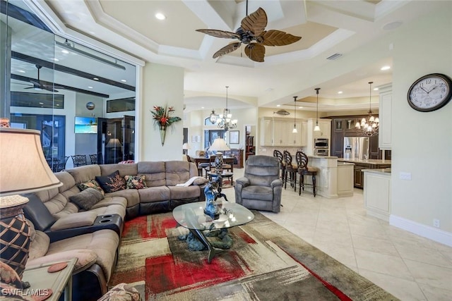 living area with light tile patterned floors, baseboards, visible vents, and ceiling fan with notable chandelier