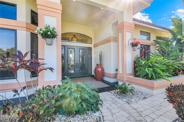 doorway to property featuring french doors and stucco siding