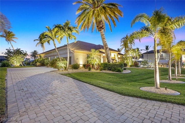 view of front of home featuring decorative driveway and a front yard