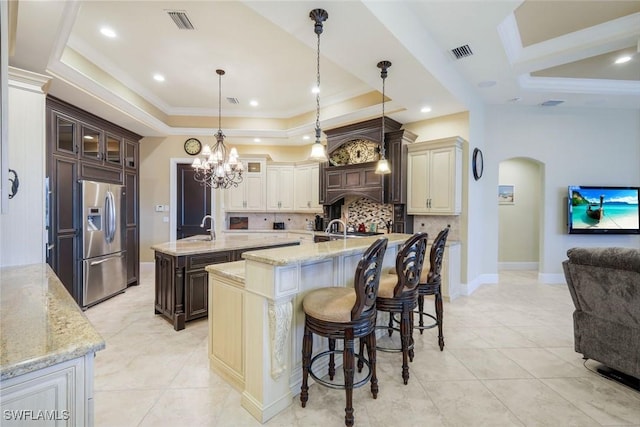 kitchen with open floor plan, dark brown cabinets, stainless steel refrigerator with ice dispenser, and glass insert cabinets