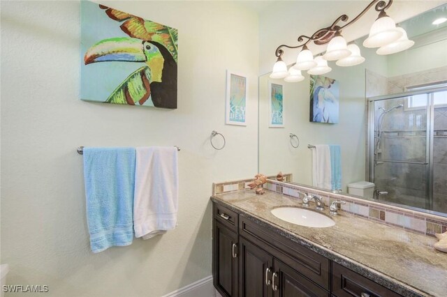 bathroom with toilet, a shower stall, and vanity