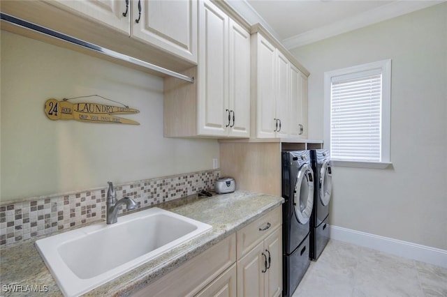 laundry area with washer and clothes dryer, cabinet space, ornamental molding, a sink, and baseboards