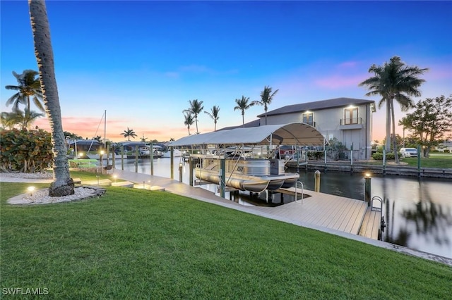 view of dock with a lawn, a water view, and boat lift