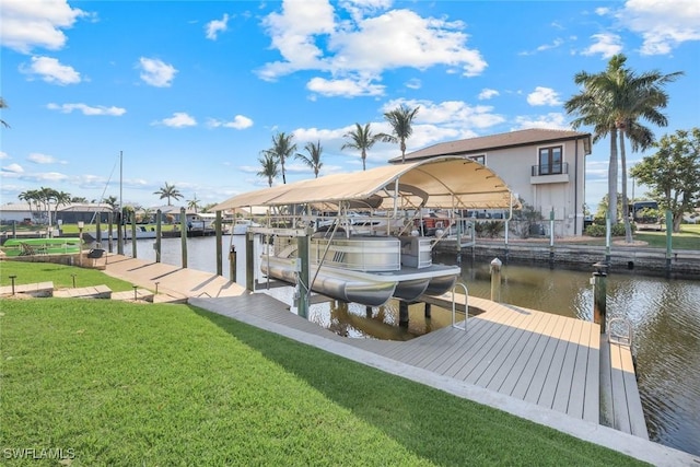 view of dock with a water view, boat lift, and a yard