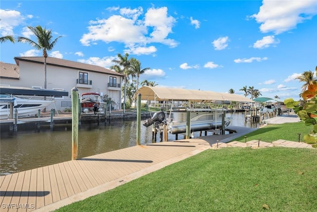 view of dock featuring a lawn, a water view, and boat lift