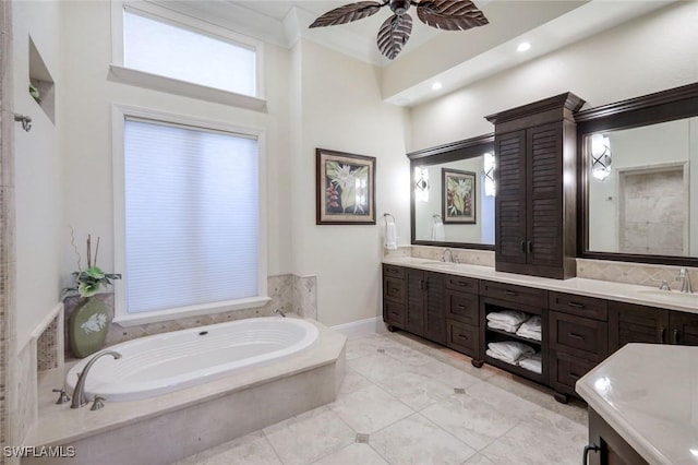 bathroom with ceiling fan, a garden tub, a sink, double vanity, and crown molding