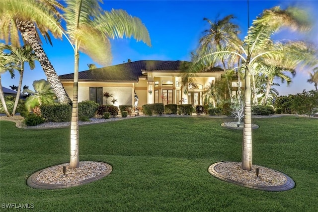 mediterranean / spanish-style home featuring a front yard and stucco siding