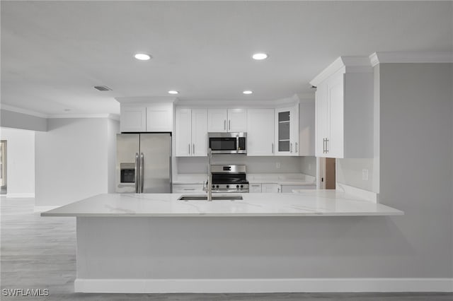 kitchen featuring light stone counters, recessed lighting, white cabinets, appliances with stainless steel finishes, and crown molding