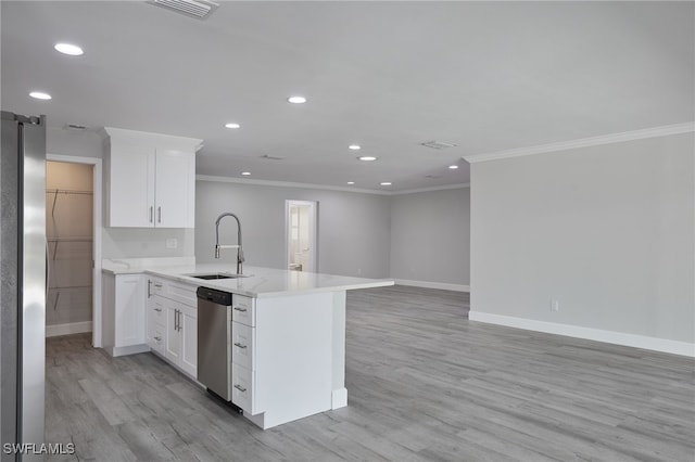 kitchen with a peninsula, a sink, white cabinetry, appliances with stainless steel finishes, and light wood-type flooring