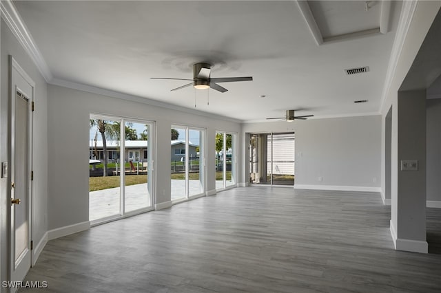 spare room featuring plenty of natural light, visible vents, and crown molding