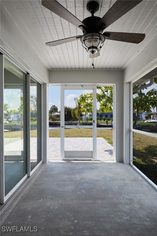 unfurnished sunroom with a ceiling fan