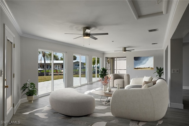 living room featuring wood finished floors, visible vents, and crown molding