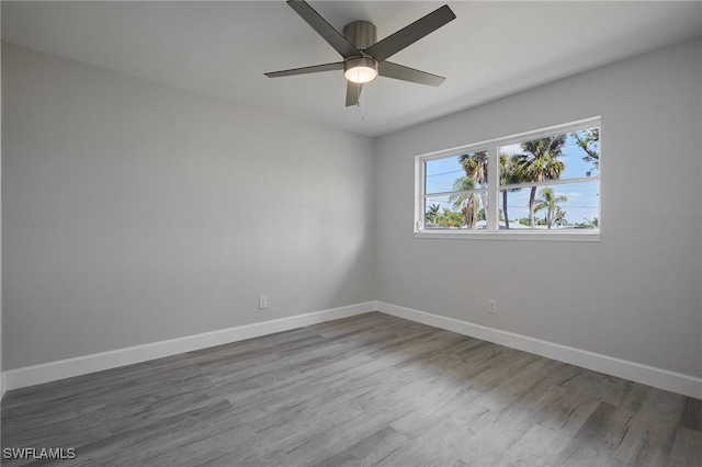 unfurnished room featuring ceiling fan, baseboards, and wood finished floors