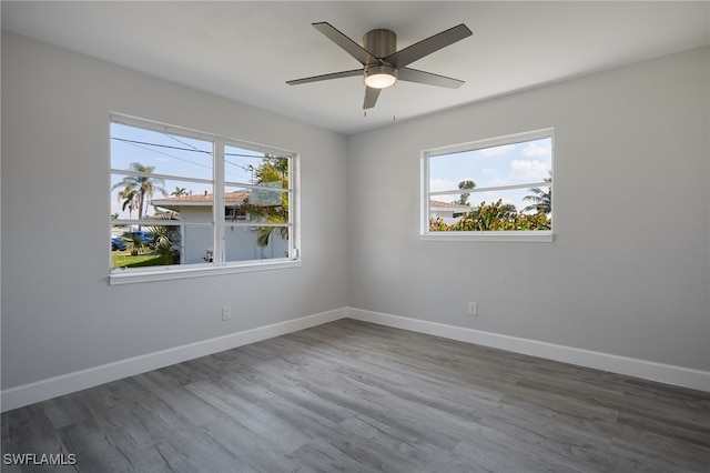 empty room featuring ceiling fan, wood finished floors, and baseboards