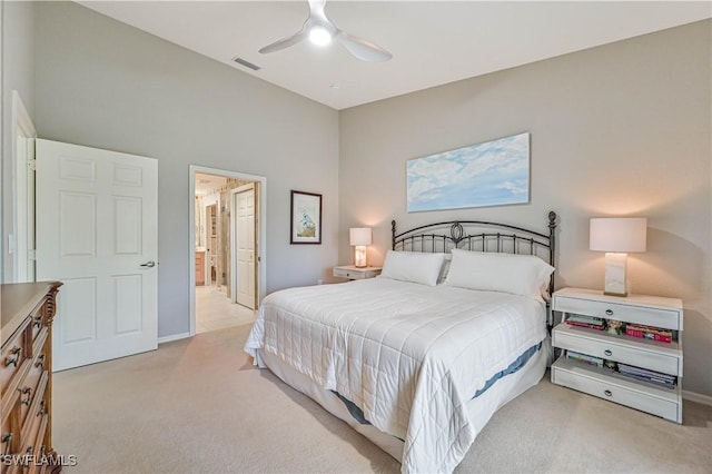 bedroom featuring light colored carpet, ceiling fan, visible vents, and ensuite bath