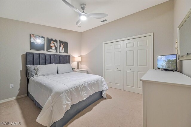 bedroom with a closet, visible vents, light carpet, ceiling fan, and baseboards