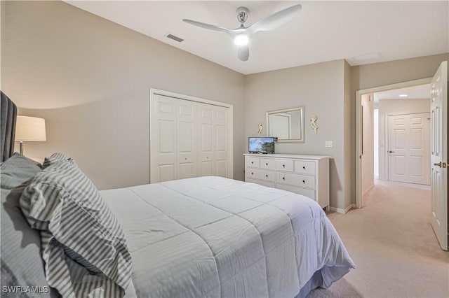 bedroom featuring a closet, light colored carpet, visible vents, ceiling fan, and baseboards