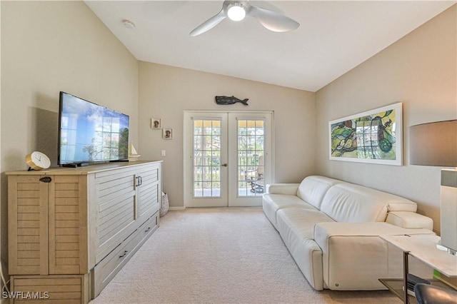 living area featuring a ceiling fan, vaulted ceiling, french doors, and light colored carpet