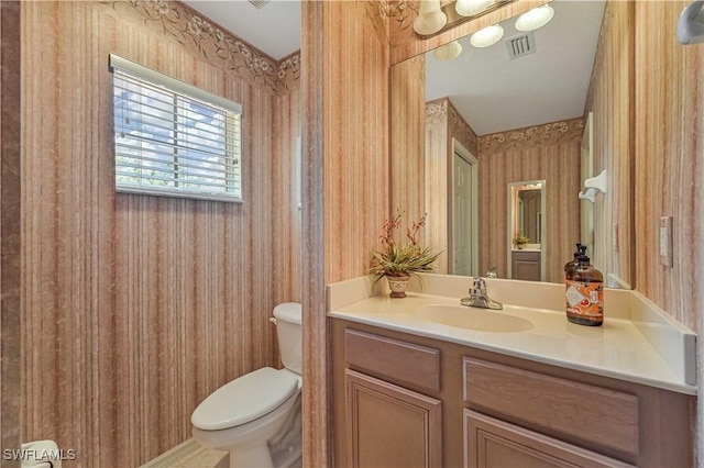 bathroom featuring toilet, visible vents, and vanity