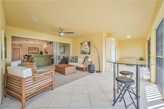 living room with a ceiling fan, light colored carpet, and light tile patterned flooring