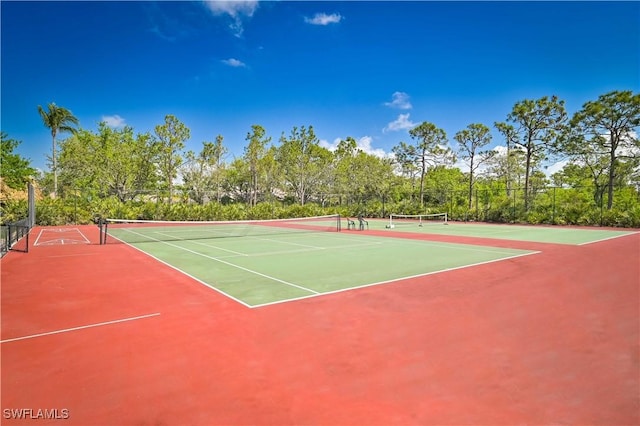 view of tennis court featuring community basketball court and fence