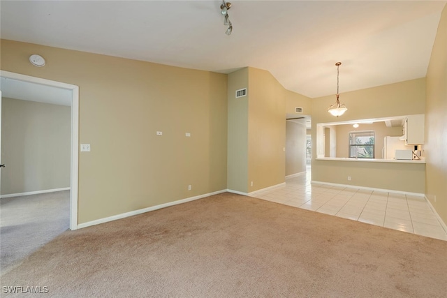 unfurnished living room featuring light carpet, light tile patterned floors, visible vents, lofted ceiling, and track lighting