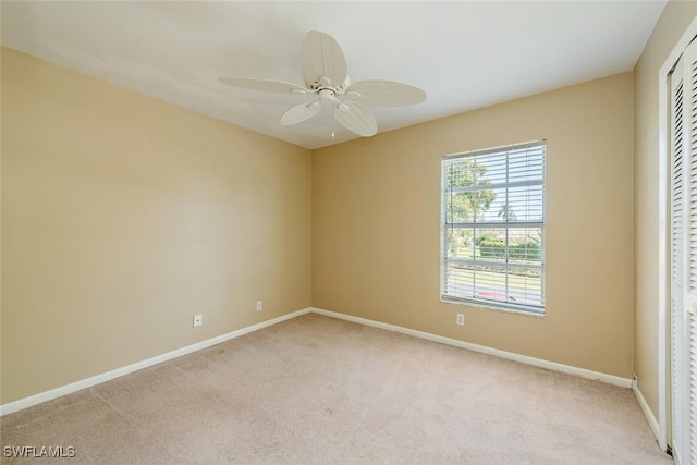 unfurnished room with a ceiling fan, carpet, and baseboards