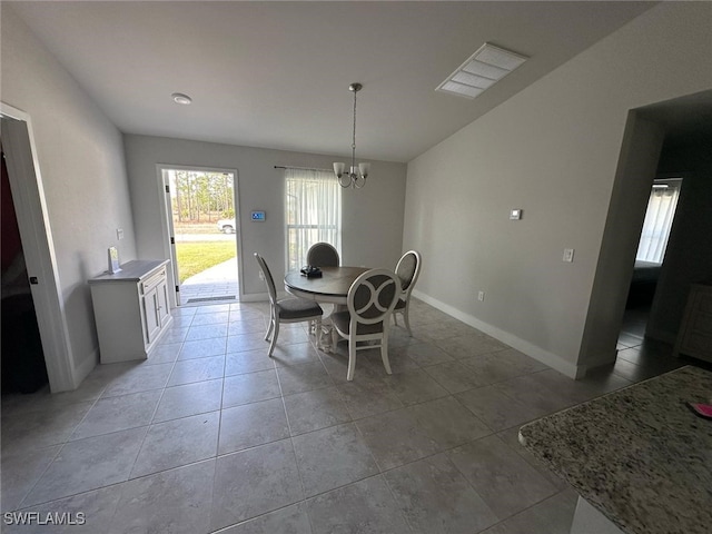 dining space featuring light tile patterned floors, vaulted ceiling, baseboards, and an inviting chandelier