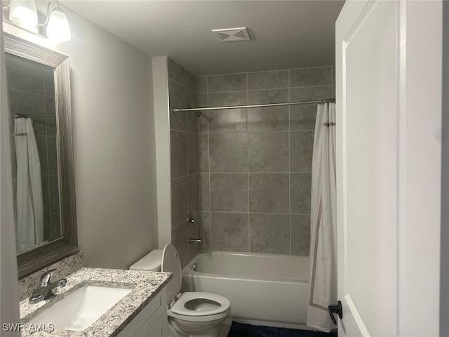 full bathroom featuring toilet, shower / tub combo, vanity, and visible vents