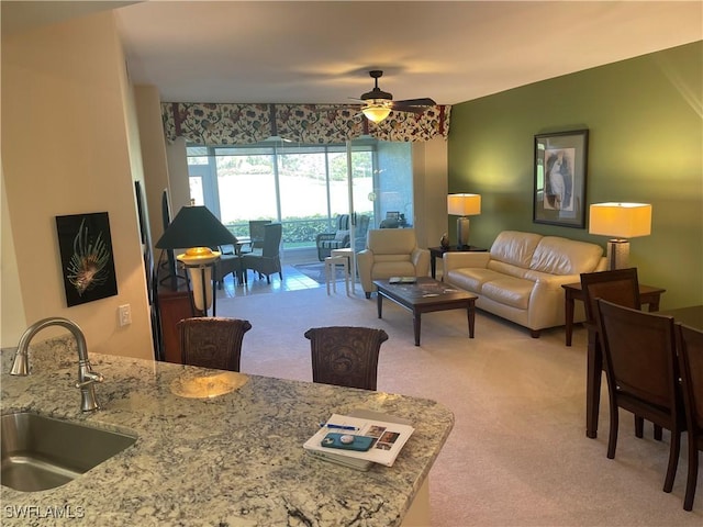 living area featuring ceiling fan and light colored carpet