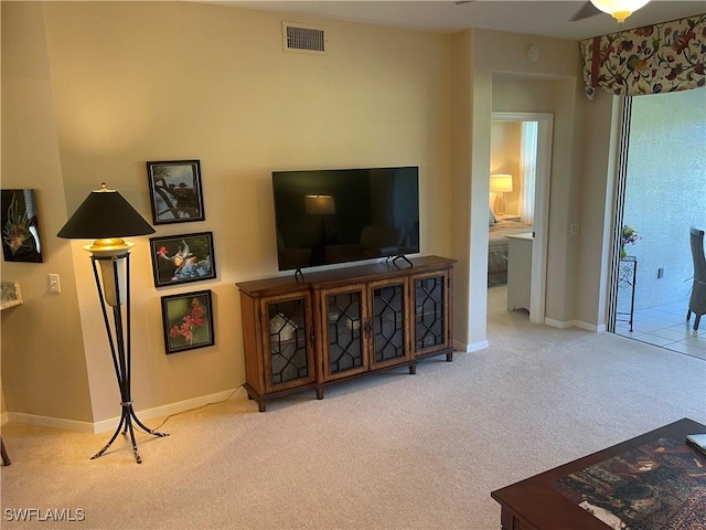 carpeted living area with baseboards and visible vents