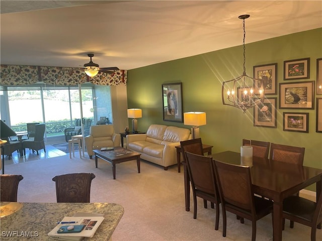 dining space featuring ceiling fan with notable chandelier and light colored carpet