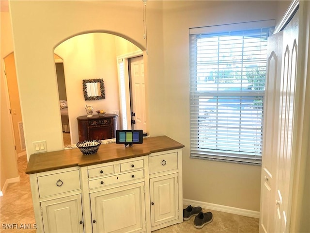 interior space featuring arched walkways, visible vents, and baseboards