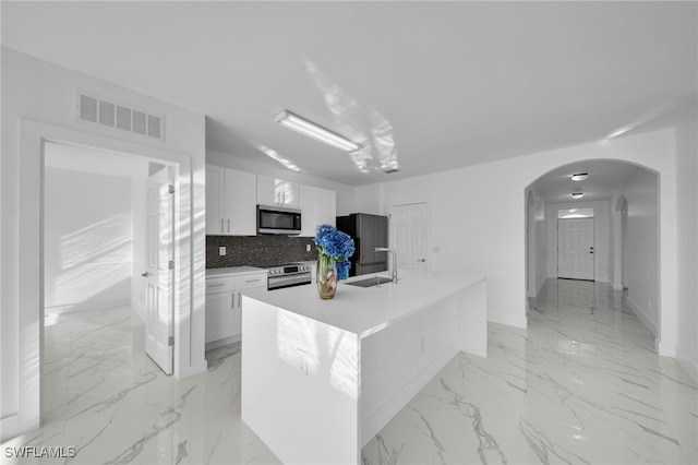 kitchen featuring light countertops, visible vents, appliances with stainless steel finishes, white cabinets, and an island with sink