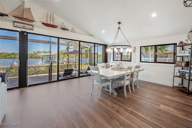 dining room featuring lofted ceiling, a water view, plenty of natural light, and wood finished floors