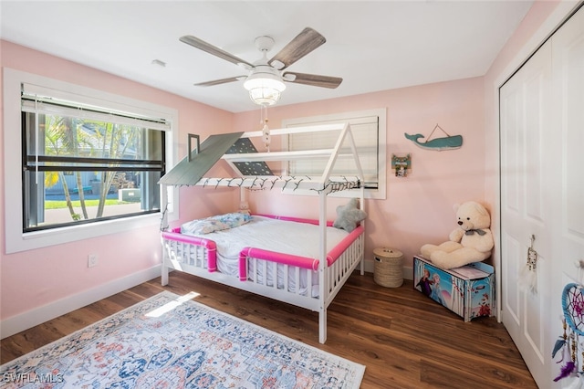 bedroom featuring ceiling fan, a closet, wood finished floors, and baseboards