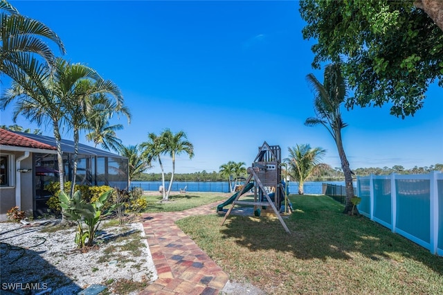 view of jungle gym with a lawn, a water view, a lanai, and a fenced backyard