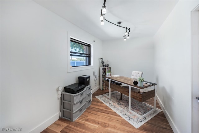 office area with rail lighting, baseboards, and wood finished floors